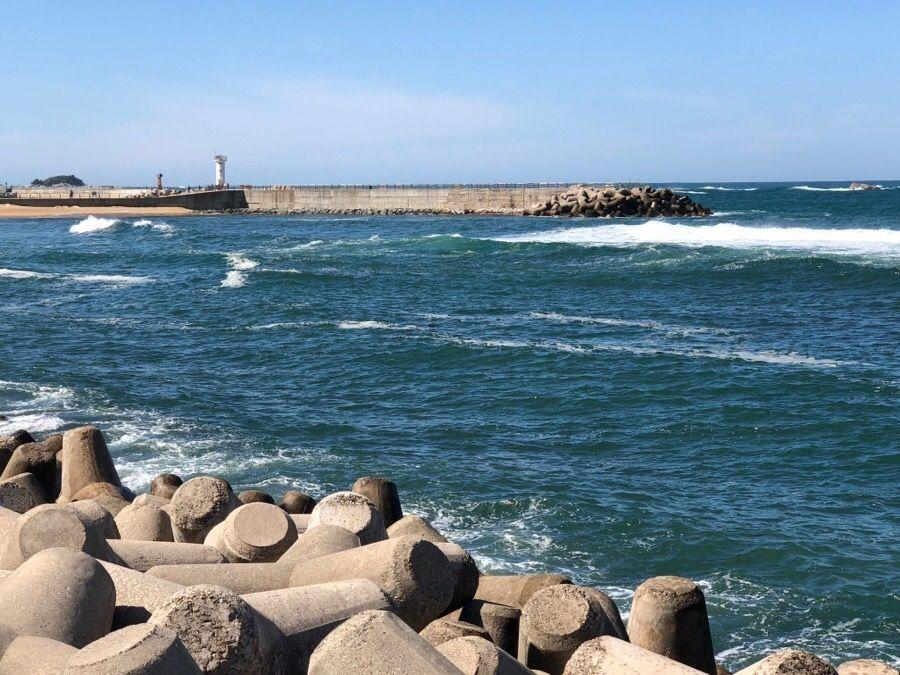 韓國束草燈塔海邊的防波堤及燈塔，遠望大海波浪。